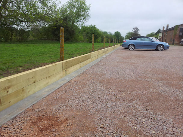 Car/Lorry park with drainage gulley and sleeper retaining wall 